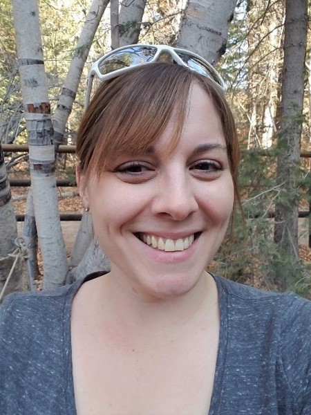 Photo of Kayla Pritchard, outdoors in the woods, smiling. 