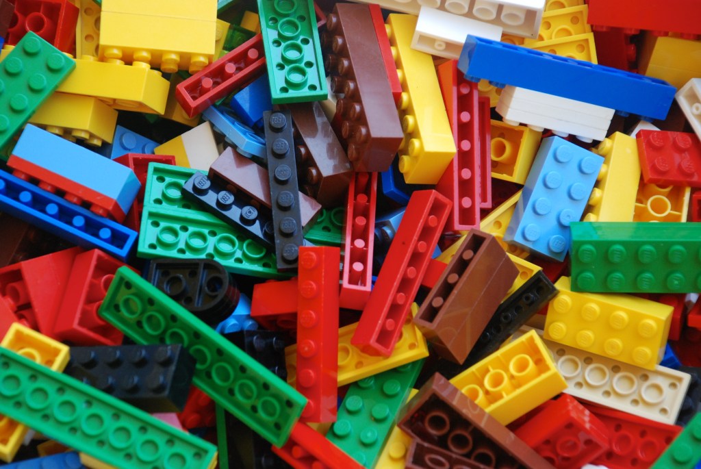 Lots of Lego blocks of a variety of colors, unorganized. 