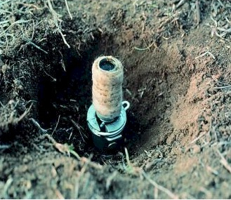 Small cylinder placed in a hole in the ground. 