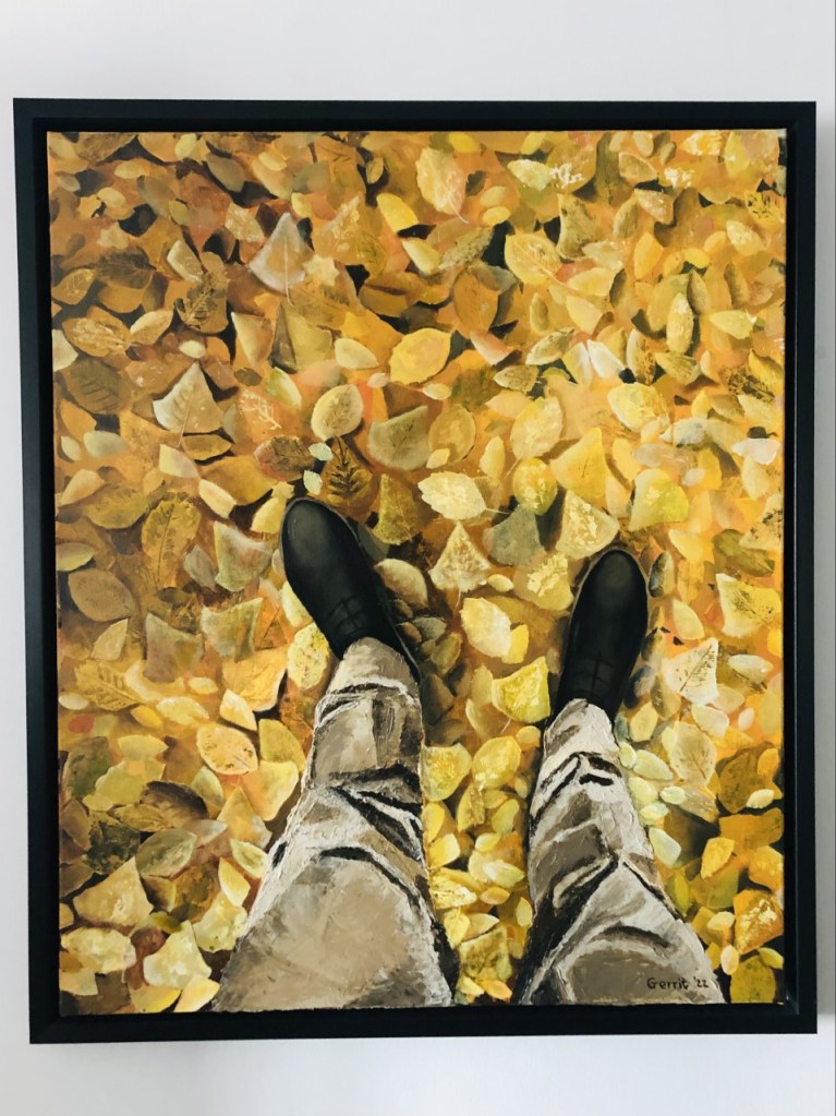 A painting depicting yellow autumn leaves on the ground, viewed from above, with legs and feet standing on the leaves. 