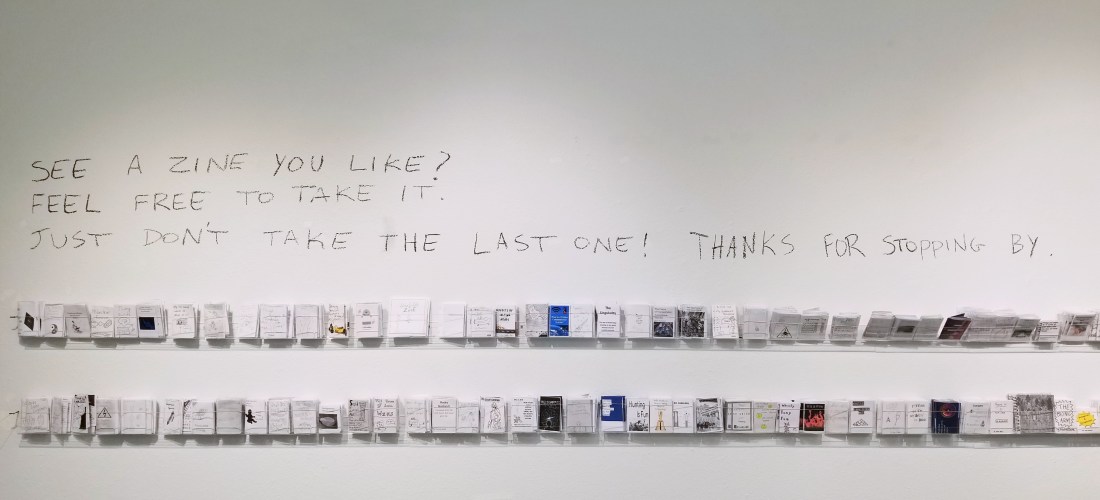 Two rows of zines on the wall in the Apex Gallery.
