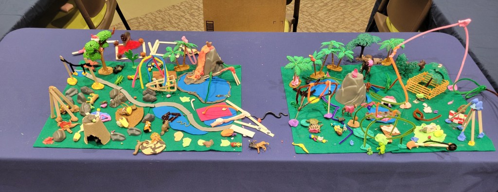 Two green felt park spaces with trees and paths and ponds and animals, etc. 