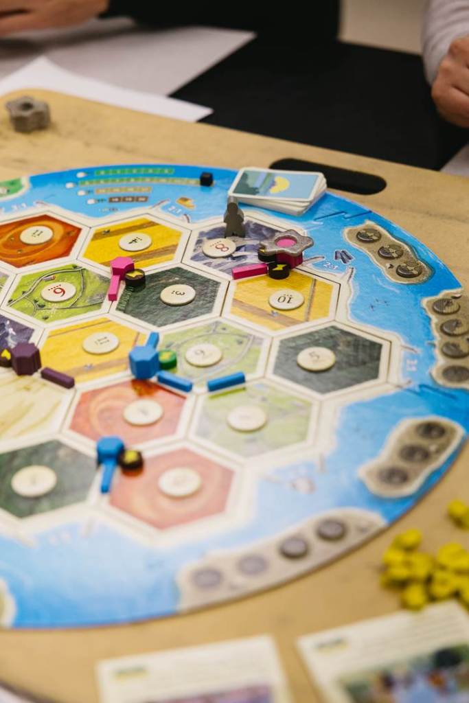 A Catan game board midway thorugh play, featuring tokens distributed across the game world. 